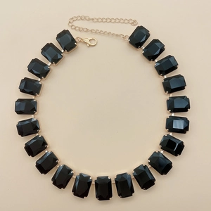 Close-up of black rectangular crystal necklace with gold chain and lobster clasp closure