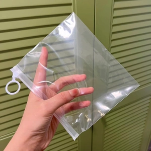Transparent plastic storage bag with white zipper seal and circular hanging hole