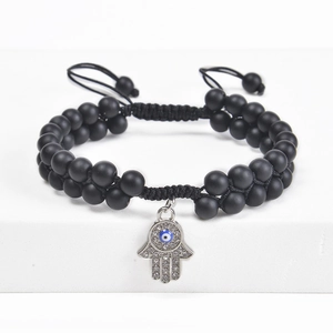 Detailed close-up of Hamsa Hand bracelet with black beads and blue Evil Eye charm