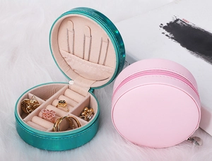 Detail of round jewelry box with zipper in blue and pink showing interior storage slots