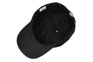 Détail d'une casquette noire en coton avec boucle en métal et étiquette de composition