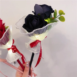 Detail of LED glowing artificial rose pen with white lace mesh and LOVE ribbon