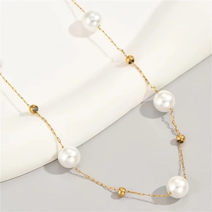 Detail shot of a minimalist gold chain necklace with large white pearls and gold beads