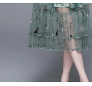 Detailed view of grey-green mesh skirt with butterfly embroidery and sequin embellishments