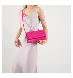 Detailed view of pink quilted handbag with geometric triangle pattern and gold hardware
