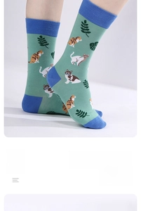 Detail of green mid-calf cotton socks featuring cat patterns and comfortable ribbed cuffs