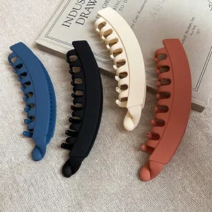 Lot de 4 barrettes banane en acrylique mat bleu noir blanc et rouge sur fond en lin