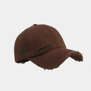 Detail view of coffee brown baseball cap with 'simple things' embroidery and distressed fabric