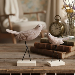 Noordse vintage houten vogelbeeldjes set met metalen poten op rustieke houten tafel