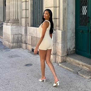 Vista laterale del body beige con nodo e spalle scoperte in tessuto a maglia operato