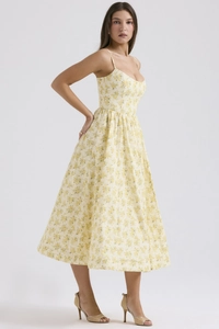 Detail of light yellow floral midi dress with spaghetti straps and pleated umbrella hem