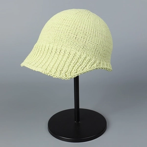 Close-up of pistachio green knitted bucket hat showing fine texture and rolled brim