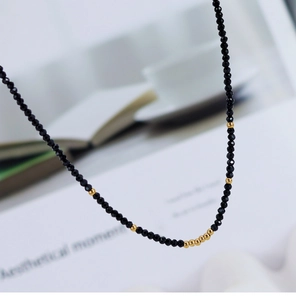 Macro shot of faceted black rhinestones and polished gold beads on a beaded necklace