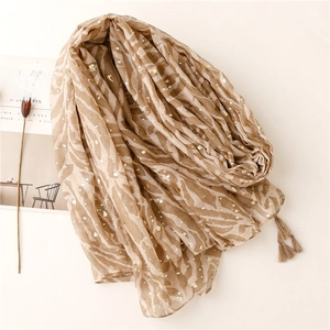 Close-up of zebra print scarf with gold foil dots and elegant fringe detail