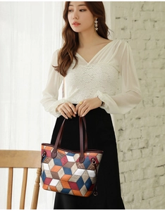 Detail of color-block tote bag with geometric stitching and reinforced leather handles