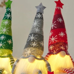 Three glowing Christmas gnomes with LED lights, knitted snowflake hats and plush beards
