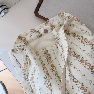 Detailed shot of floral cotton bag featuring metal magnetic buckle and side logo label