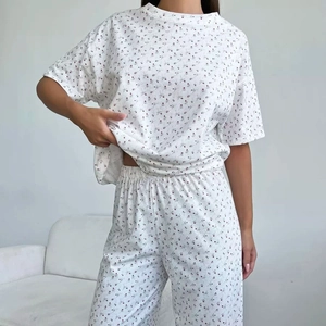 Women's two-piece floral pajama set with short-sleeved top and long pants in white cotton
