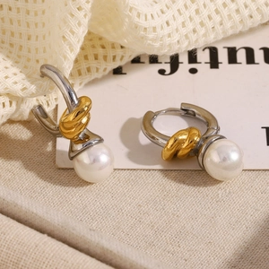 Close-up of gold and silver knotted hoop earrings featuring elegant white round pearls