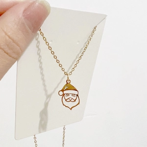 Détail d'un collier avec pendentif Père Noël doré en acier titane de haute qualité