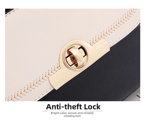 Detail of the golden circular twist lock on a minimalist cream and black handbag
