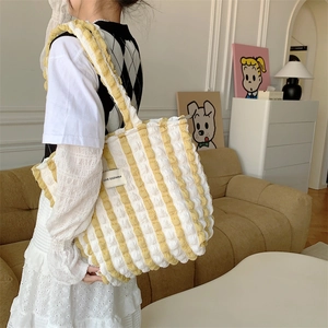 Detail of yellow striped popcorn fabric tote bag with LOVE SOZAKKA label on model