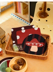 Detail of round and square mushroom coasters in a woven tray with red polka dots