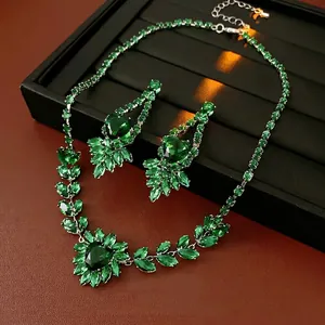 Luxury silver emerald heart jewelry set with necklace and earrings on velvet tray
