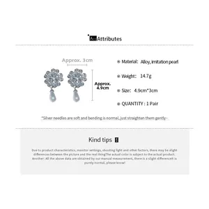 Detail view of floral earrings featuring sparkling rhinestones and teardrop pearls