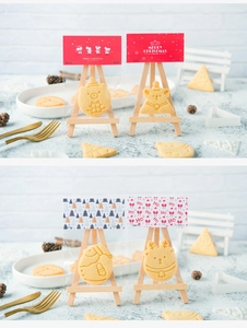 Close-up of Christmas cookies in festive packaging displayed on a mini wooden easel
