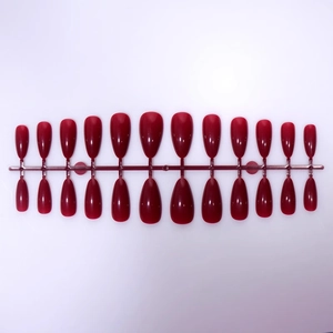 Deep red almond-shaped press-on nails set with glossy finish on plastic frame