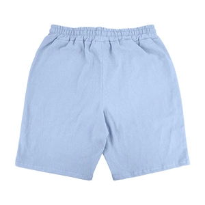 Close-up of light blue linen shorts featuring a textured fabric and elastic waistband
