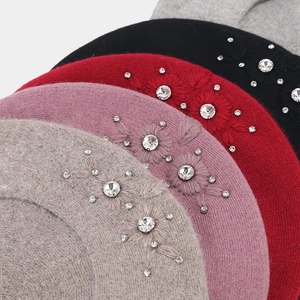 Detail of wool blend beret featuring flower embroidery and sparkling rhinestones