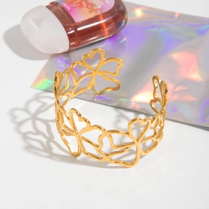 Detail of 18K gold plated stainless steel open bangle with hollow floral lace pattern