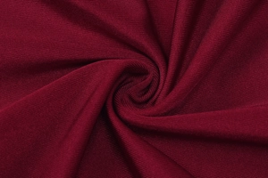 Close-up of deep red ribbed knit fabric showing soft texture and premium drape