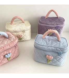 Corduroy makeup bags in beige, purple, pink, and blue with quilted floral detail