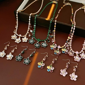 Top view of crystal flower jewelry sets with zircon pendant necklaces and earrings