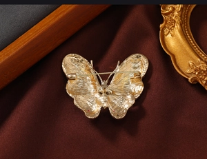 Macro shot of the vintage champagne gold butterfly brooch back with safety pin clasp