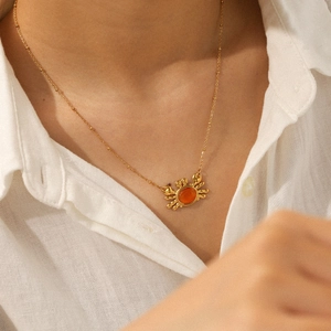 Gold stainless steel necklace with cat eye stone crab pendant on model neckline