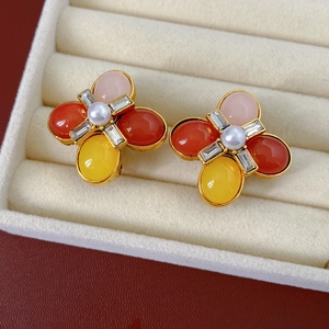 Détail de boucles d'oreilles vintage avec pierres colorées et perle dans un écrin à bijoux