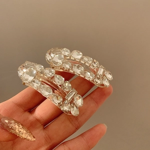 Handheld view of two sparkling rhinestone hair clips in round and rectangular shapes