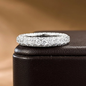 Macro shot of silver full eternity ring with round cut stones on leather jewelry box