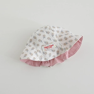 Detail of baby sun hat with reversible floral print and soft pink cotton fabric surface