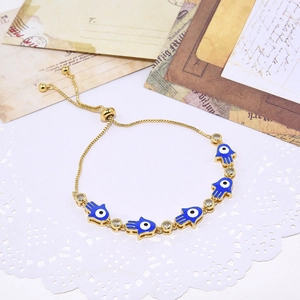 Gold Hamsa Hand bracelet with blue evil eye charms and sparkling zircon stones