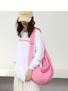 Dettaglio della borsa a mezzaluna in nylon rosa con ampia tracolla regolabile e capiente