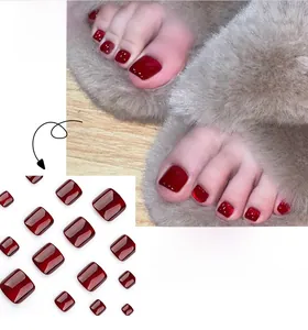 Glossy cherry red square press-on toe nails displayed on a model in plush slippers