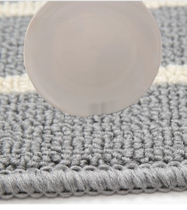 Detail of woven polypropylene kitchen mat texture showing thick cushioning and grey fiber