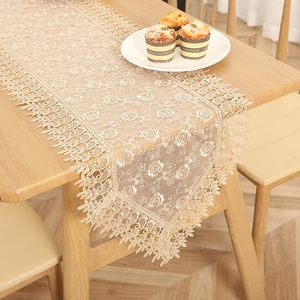Elegant beige lace table runner with hollow embroidery, French luxury style for dining table.