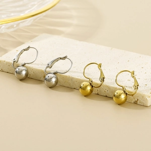 Detailed view of silver and gold stainless steel hoop earrings with polished beads