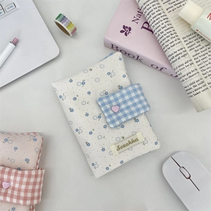 Detailed view of floral fabric book covers with grid straps and heart shaped buttons